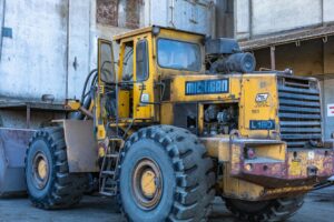 Commercial truck tires showing radial and bias ply construction beside a work vehicle on a paved lot